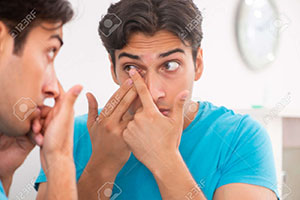 man inserting contact lens